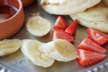 close up of slice of banana and strawberry on a plate 