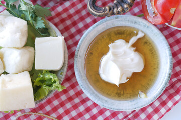 butter cream and honey in a bowl on table .