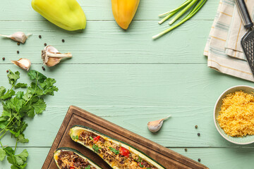 Frame made of meat stuffed zucchini boats and ingredients on green wooden background