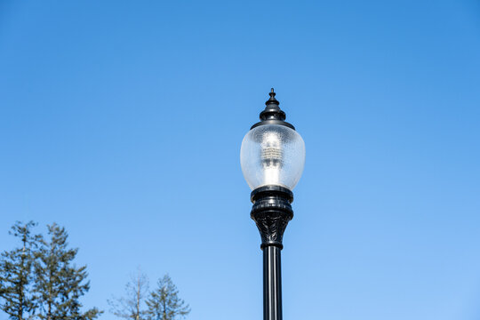 Modern new LED streetlight in a classic traditional style, against a sunny blue winter sky
