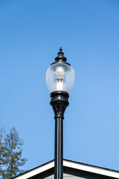 Modern new LED streetlight in a classic traditional style, against a sunny blue winter sky
