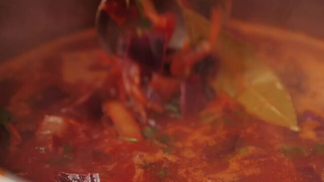 Beetroot soup, Cooking traditional national Russian, Ukranian soup Borsch close-up. Boiling red soup with vegetables and turkey meat and spices. Special red for Borsh from beet, tomatoes pasta