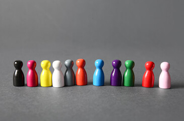 Row of colorful human figures on grey background. Inclusion concept