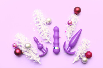 Purple sex toys and Christmas decor on lilac background