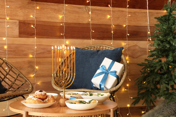 Interior of living room with festive dinner, glowing lights and traditional Hanukkah decorations