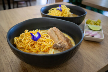 Thai noodles Khao Soi, spicy curry with seasoning on table