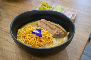 Thai noodles Khao Soi, spicy curry with seasoning on table