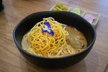 Thai noodles Khao Soi, spicy curry with seasoning on table