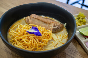 Thai noodles Khao Soi, spicy curry with seasoning on table