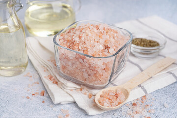 Glass bowl and spoon with Himalayan pink salt on white background