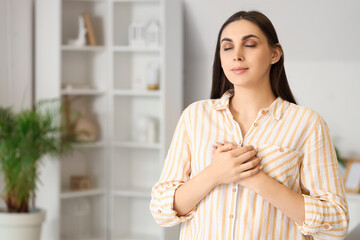 Beautiful woman praying at home