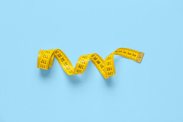 Yellow measuring tape on blue background