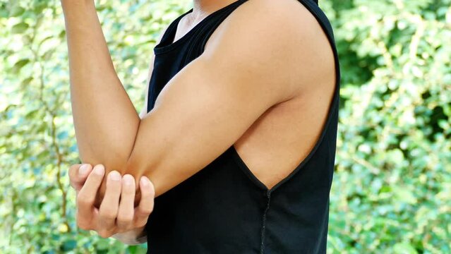 An Asian man Pain in his elbow, he holds his elbow because of the pain.