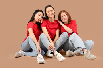 Beautiful young women sitting on beige background. Women history month
