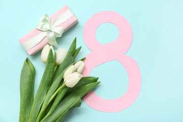 Figure 8 made of paper with gift box and bouquet of beautiful white tulips on blue background. International Women's Day