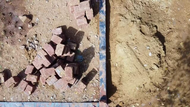 Construction using earthen blocks, Building the foundation of the house, Workers work at a construction site in India, Building a house with red stone , Works using cement ,