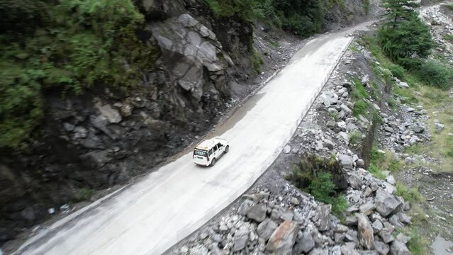 Tourists in SUV Car Driving on Streep Mountain Road Towards Jomsom in Nepal - Aerial Tracking