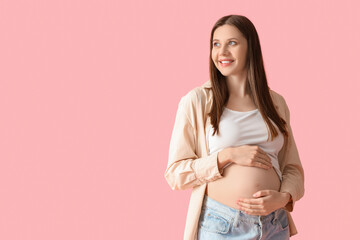 Young pregnant woman on pink background