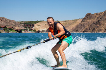 a man on a surfboard. a guy on a wave on a wakeboard