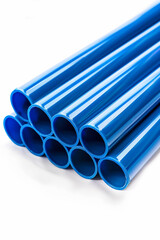 Diagonal arrangement of blue PVC pipes with selective focus on a white background, highlighting industrial materials and plumbing concepts
