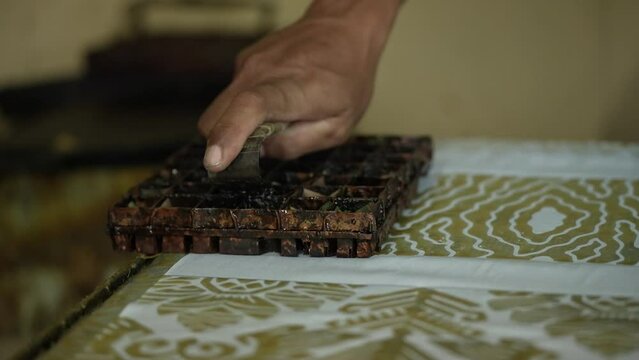 Close-up view of the batik stamping process. Making batik cloth by stamping.