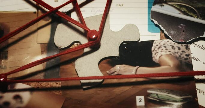 Cluttered investigation board with various items including photographs, papers, and red strings connecting different points