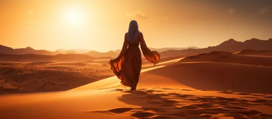 Foto op Plexiglas Silhouette view of beautiful muslim woman walking on desert sand © Media Srock