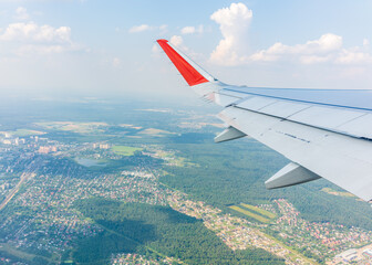 Fototapeta premium View from the airplane window during taking off on a clear summer morning