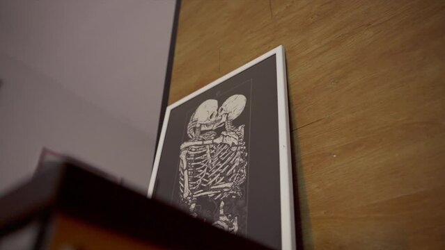 Low angle view of a photograph with two skeletons kissing each other. Blurred foreground.