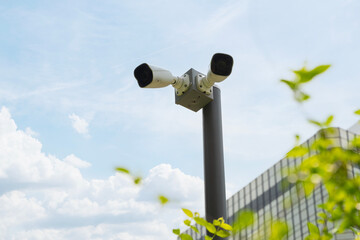 CCTV camera, Two high-definition security cameras are mounted on a pole in front of a bank.