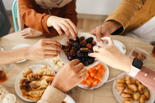 Happy muslim family having iftar together and sharing a bowl of dates 