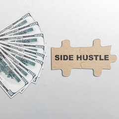 Text of side hustle on puzzle with dollars money on the next isolated over white background. Side...