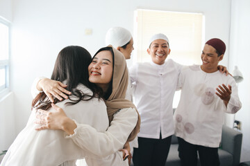 Young muslim women in hijab hugging and smiling during Eid mubarak celebration. Islamic culture and tradition concept - obrazy, fototapety, plakaty