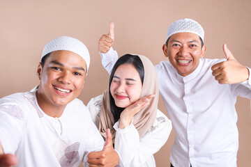 Cheerful Asian muslim friends taking selfie together 