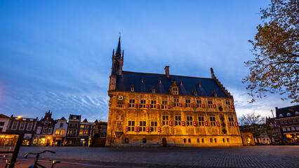 A scenic view of Stadhuis van Gouda, is old City Hall of Gouda in the Netherlands during nighttime.