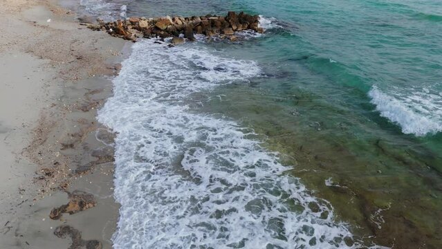 Beautiful aerial view demonstrating waves hitting the beach in Afytos, Chalkidiki, Greece (slow motion)