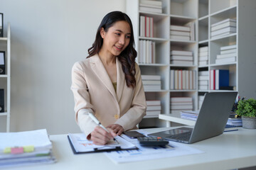 Asian businesswoman working on laptop Online document database, analyzing financial reports Data recording and document management system concepts. Automate actions to manage files efficiently.