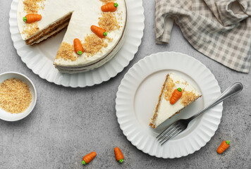 Homemade carrot cake made with walnuts, iced with cream cheese. Sweet dessert.