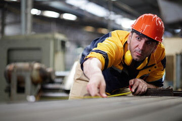 worker or technician using tape measure and measuring the length of the machine in the factory