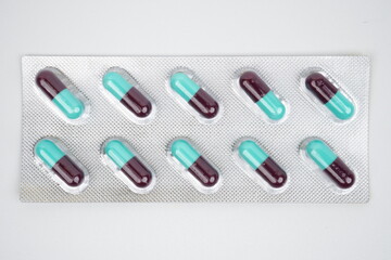 Top view of purple and tosca pill capsules in silver blister pack 1