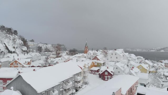 Distant View Of Kragero Church Bell Tower And Snowy Houses In Winter In Telemark County, Norway. drone shot