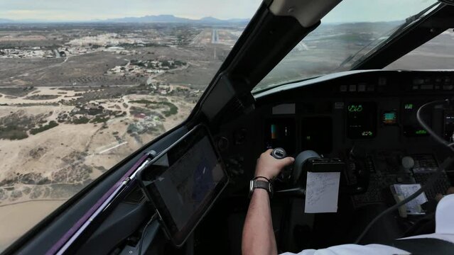 Pilot POV FPV perspective piloting a jet approaching to the runway of a coastal desert airport. Captain side. Real time flight. Daylight. 4K 60FPS
