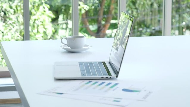 Meeting room Office laptop business financial document chart , graph on wooden table with coffee cup. Flat lay notebook computer laptop on office desk. No people business graph chart on meeting table