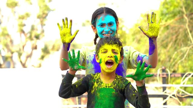 Indian kids playing with colours or asian children celebrating holi. festival of colours