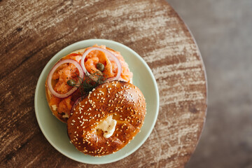 A halved bagel breakfast sandwich with scrambled eggs, spinach, and cheese on a plate