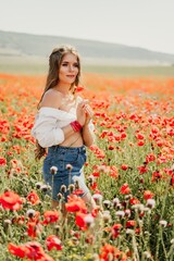 Woman poppies field. Side view of a happy woman with long hair in a poppy field and enjoying the beauty of nature in a warm summer day.