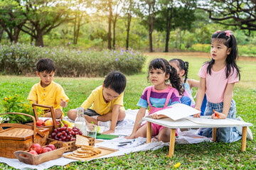 A little boy and girl were having fun drawing pictures, Group of children playing and on sunny summer day in the park,  holiday relaxation concept, picnic in summer park, outdoor education concepts
