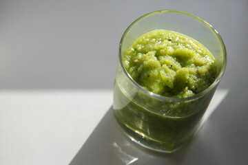 Celery smoothie, apple and kiwi in a clear glass