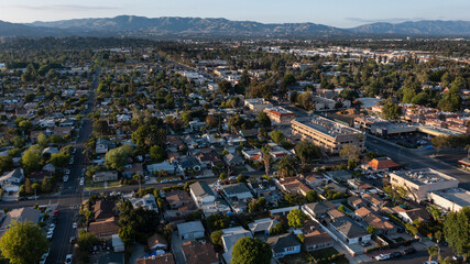 Los Angeles, California, USA - May 7, 2023: Sunset light shines on businesses in the urban core of downtown Canoga Park. - obrazy, fototapety, plakaty