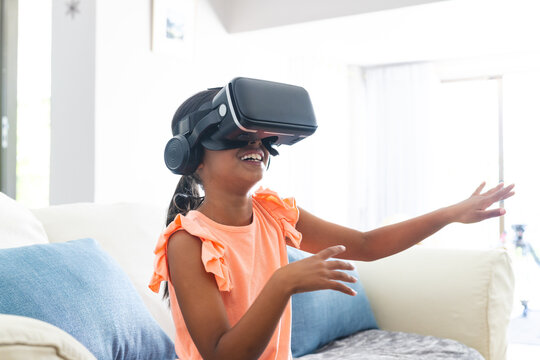 Biracial girl enjoys virtual reality at home